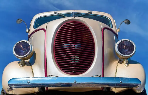 Vintage car front with large grille.