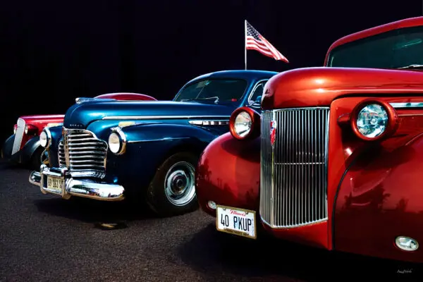 Classic vintage cars with American flag background.
