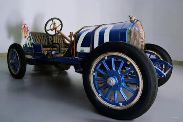 Vintage blue race car with large wheels.