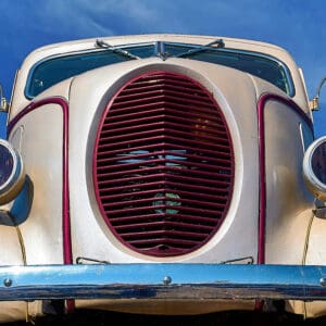 Vintage car front with large grille.