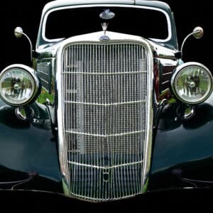 Classic vintage car front view on black.