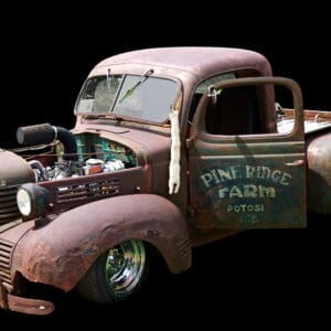 Rusty vintage pickup truck with open door.