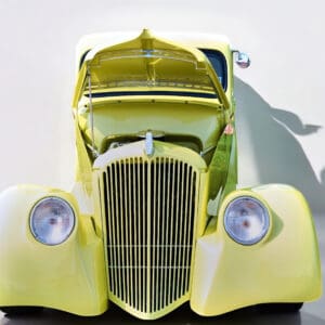 Vintage yellow car with open hood.