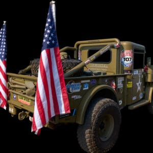 Military truck with American flags displayed.